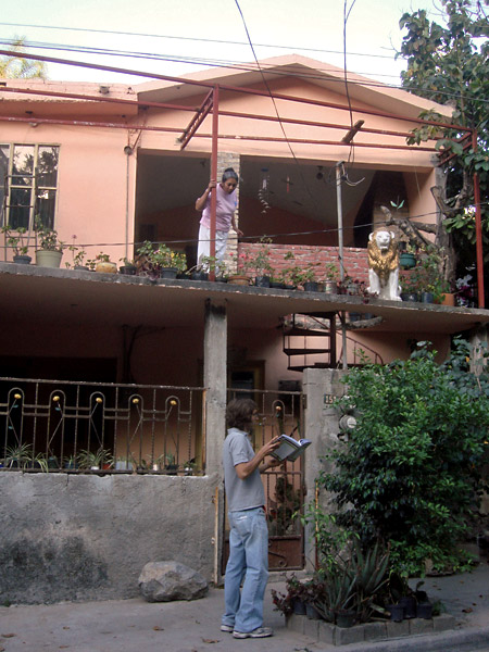 Luis preguntando a los vecinos para pintar sus paredes y enseñando el libro del proyecto 